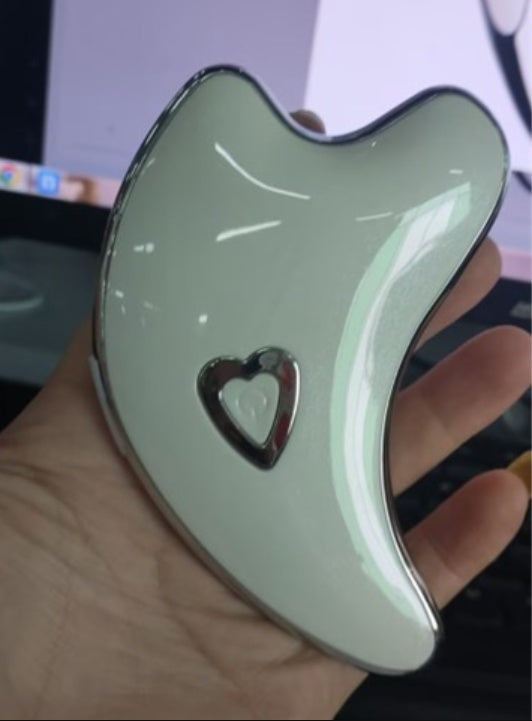 Green jade-like object with a heart-shaped cutout held by a hand.