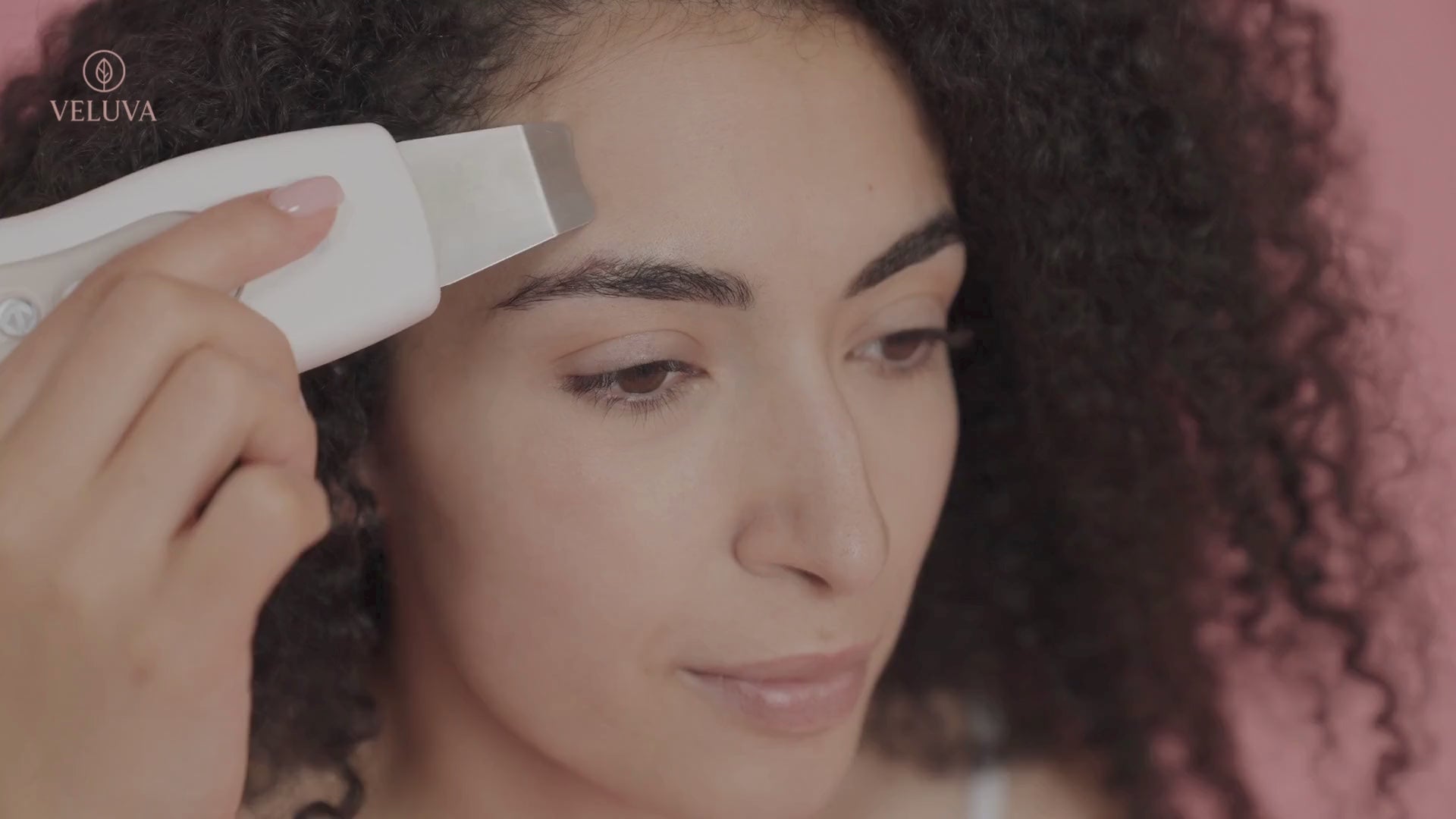 Lady using Veluva's Ultrasonic facial Cleanser 