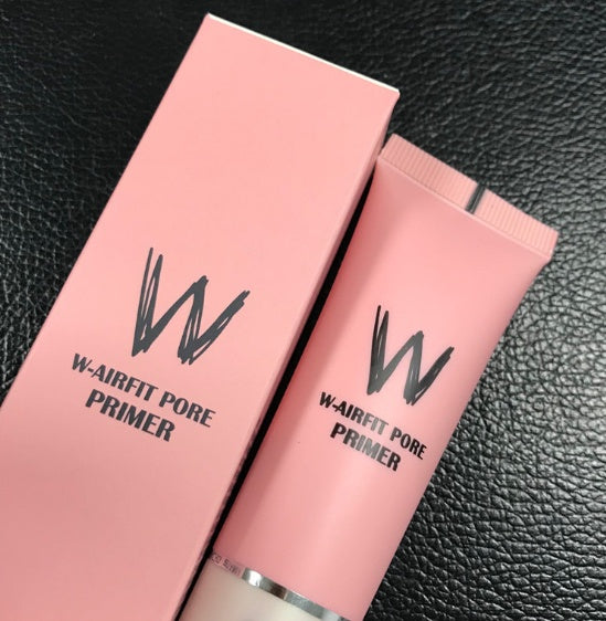 W-Airfit Pore Primer packaging with pink tube and box on a black textured background
