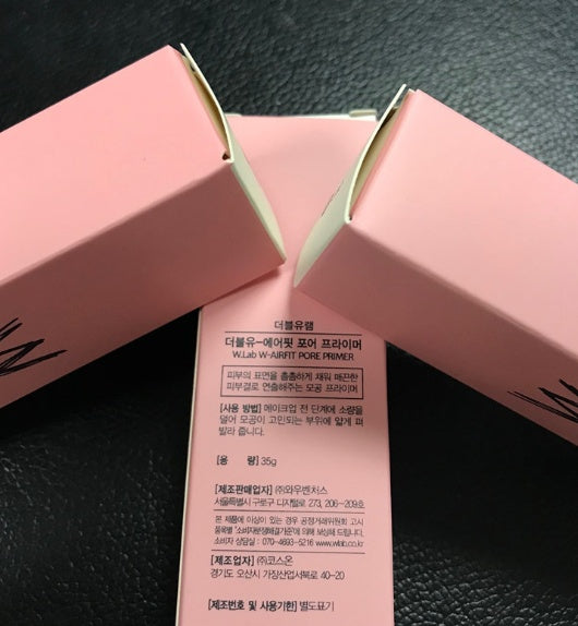 Pink cosmetic product packaging with text on a dark background