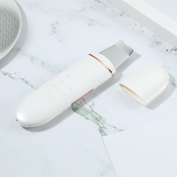 White electronic device with rose gold accents on a marble surface